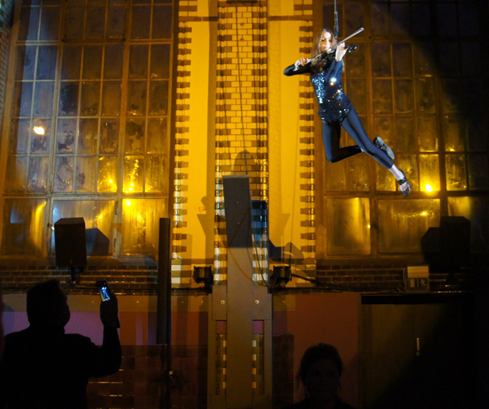 Violinistin fliegend Violinistin fliegt über den Köpfen der Gäste