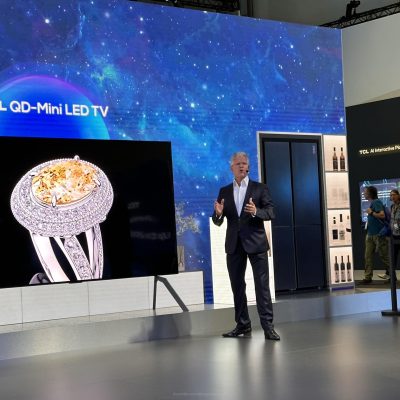 Presenter presents live on the trade fair stage in front of an audience - in German and English